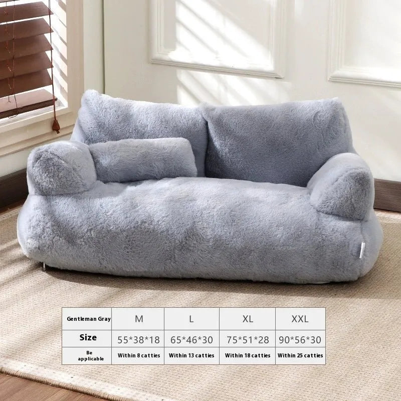 Gray plush bean bag chair in a room with a window and blinds.