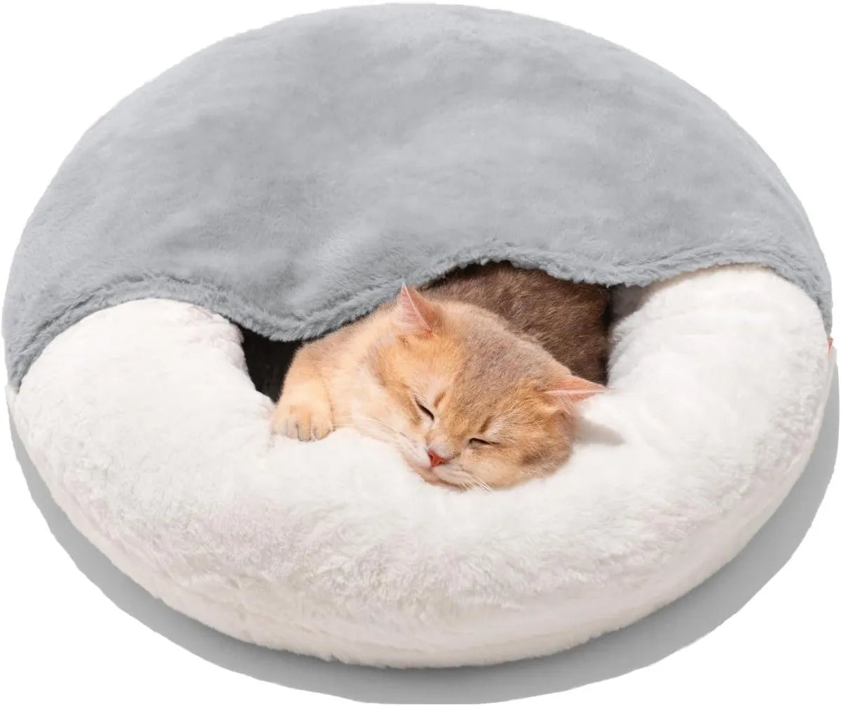 Cat sleeping in a round, plush pet bed with gray top and white bottom on a white background